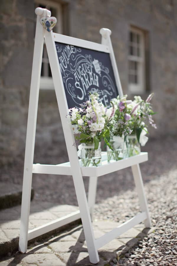 Blackboard with white frame and flowers.