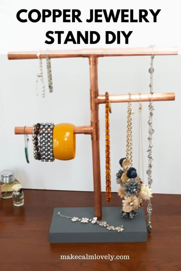 Copper pipe jewelry stand with jewelry.