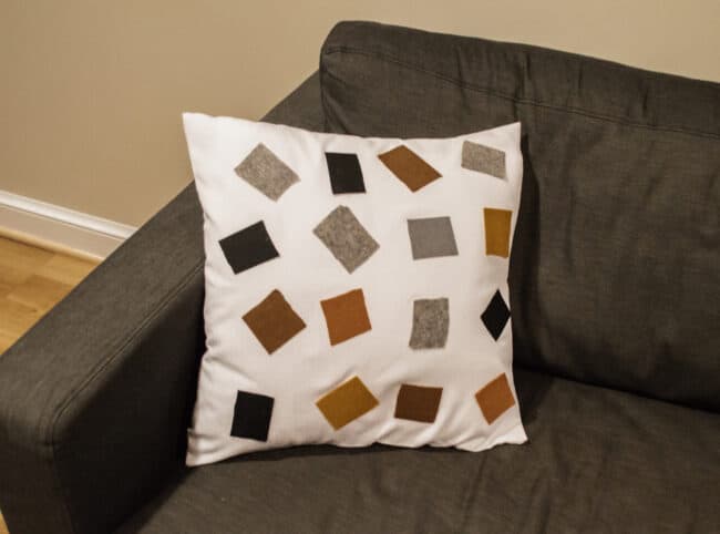 white cushion with colored felt squares 
