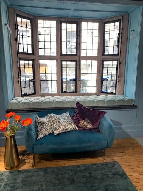 Window seat with blue sofa.