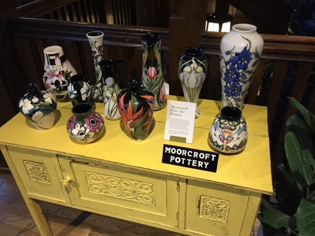 Display of Moorcroft pottery vases on a yellow chest table inside Liberty's of London.