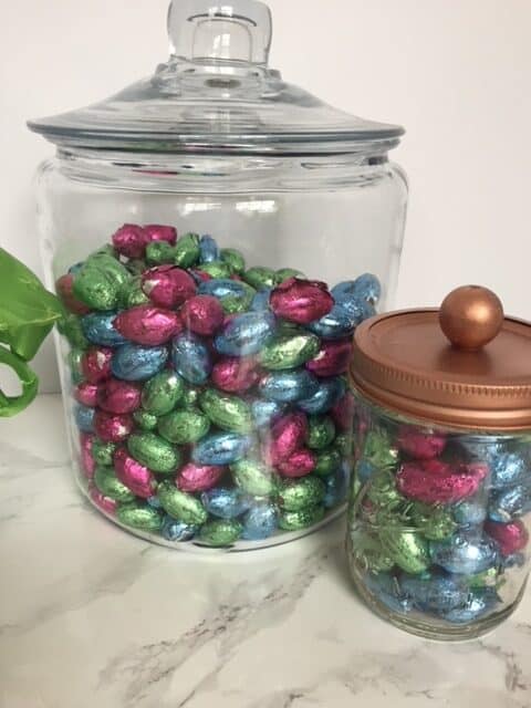 Glass jars full of colored chocolate Easter eggs.
