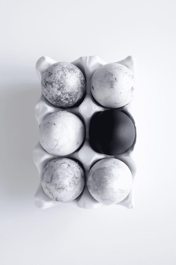 black and white decorated eggs in egg carton