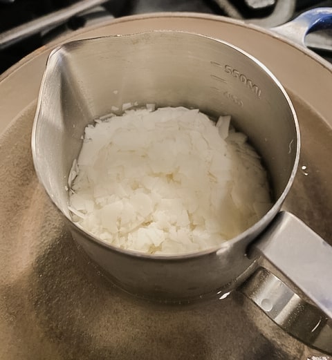 Wax flakes in metal jug