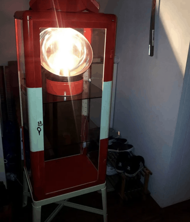 Red and blue lighthouse made from a glass cabinet.