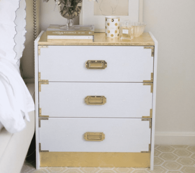 White and gold Campaign style bedside dresser.