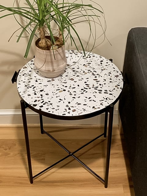 Terrazzo and black side table with plant on top.