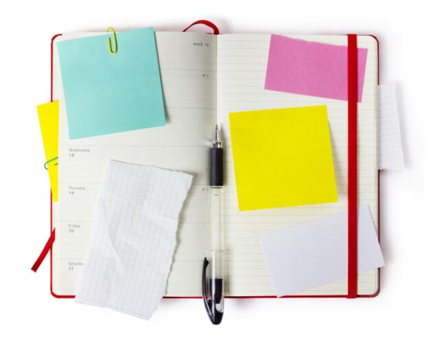 Planner open with a pen and post it notes