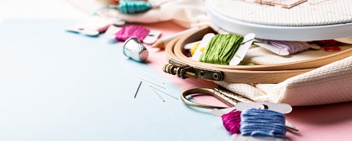 embroidery thread, scissors, thimble, needles and hoops